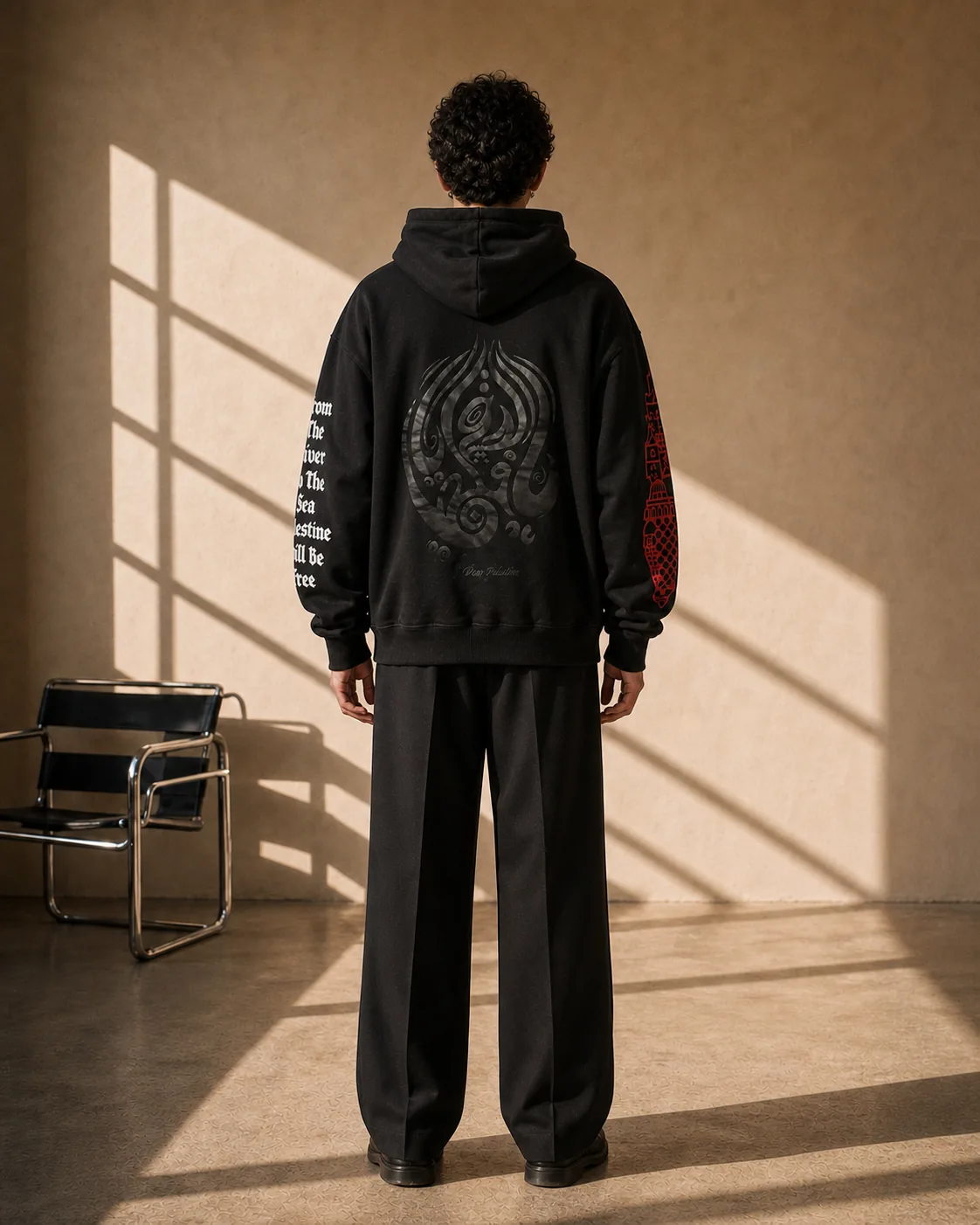 Back of the black Palestine hoodie, MY DEAR PALESTINE in black-on-black Arabic calligraphy filling the whole back, the gothic sleeve text on one arm and the red map on the other