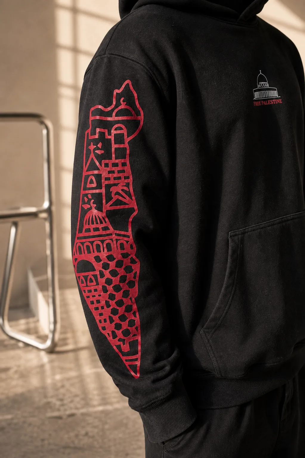 The map of Palestine drawn in red down the other sleeve, the Dome and FREE PALESTINE on the chest behind it